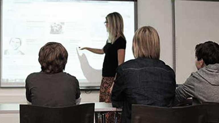 Elever undervises foran interaktiv tavle. Foto.