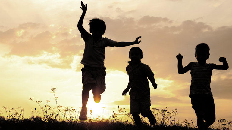 Children playing in sunset. Photo.