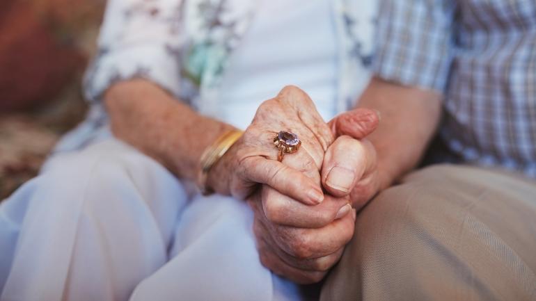Eldre mann og kvinne holder hender. Foto iStock