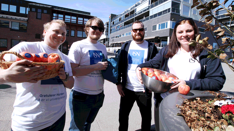 Fire USN-studenter fra campus Vestfold med eplene de deler ut i Horten sentrum.