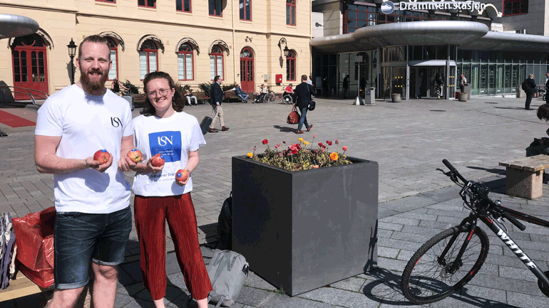 To studenter som deler ut epler i Drammen. 