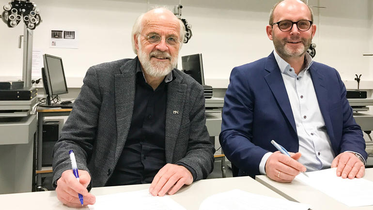 Rektor Petter Aasen og Martin Rostrup skriver under avtalen mellom USN og Rodenstock Norge. Foto