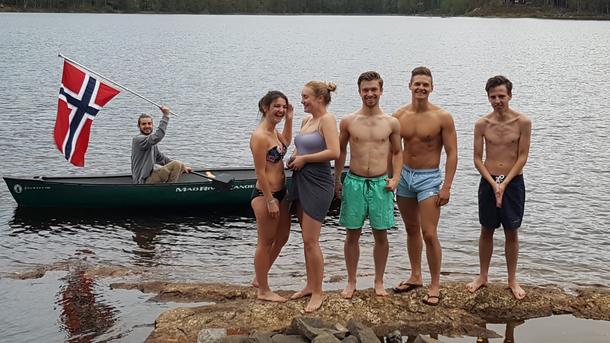 International students after a swim, with Norwagian flag in the background