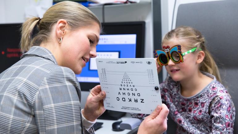 Optometristudent som sjekker synet til et barn
