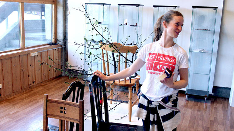 Folkekunststudent Maja Nielsen viser frem spisestolene som hun har reparert med brusflasker.