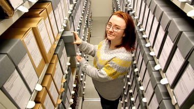 Caroline Klavenes jobber med Porsgrunds Porselænsfabrik-arkivet som avslutning på bachelor-oppgaven ved USN. Foto av henne i arkivet.