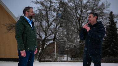 Finn Arild Thordarson og Kim Roar Strøm snakker sammen på tegnspråk ute i snøen.