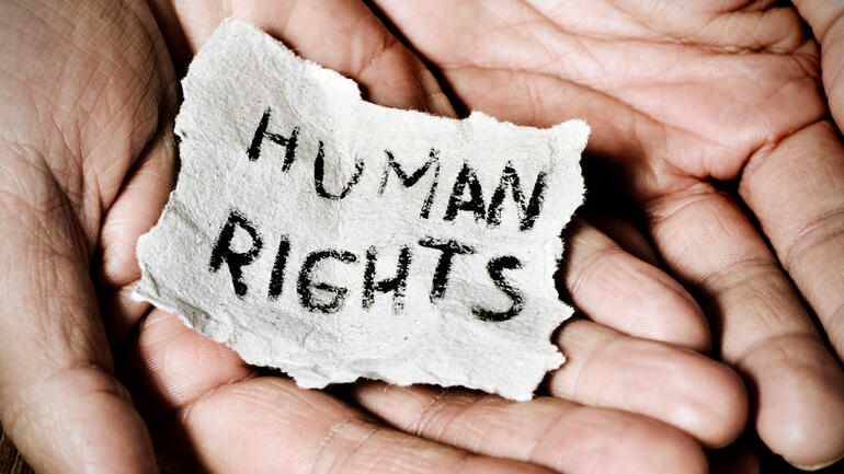 Human Rights - illustrasjonsbilde-hender med lapp og tekst.