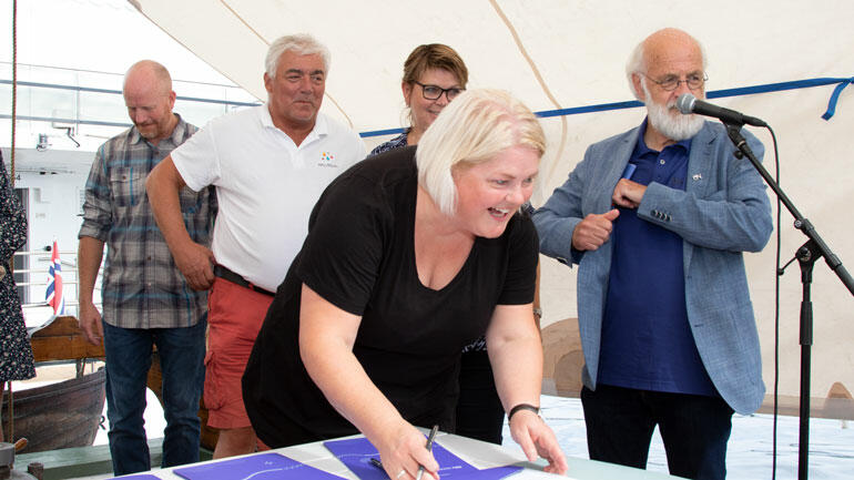 Ordfører i Ål signerer med de andre som står bak