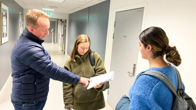 HJELP I PAUSEN: Læringsfasilitator Olav Kåsa Dehli tar seg tid til å hjelpe Siri Huseby med et spørsmål i pausen mellom øktene også.  Foto av dem i gangen på campus Kongsberg. 