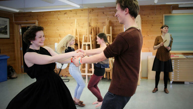 To personer dansar i eit klasserom. Foto