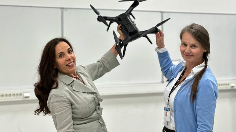 Aurilla Arntzen og Elisabet Syverud som holder oppe en drone. 