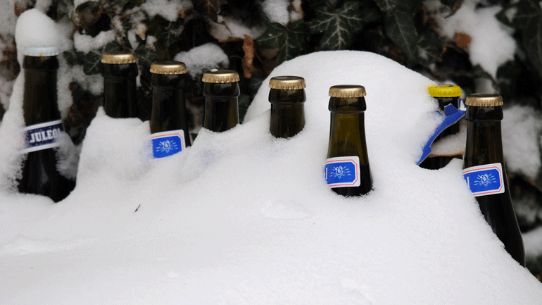 Bottles of Yule ale partially covered in the snow. Photo