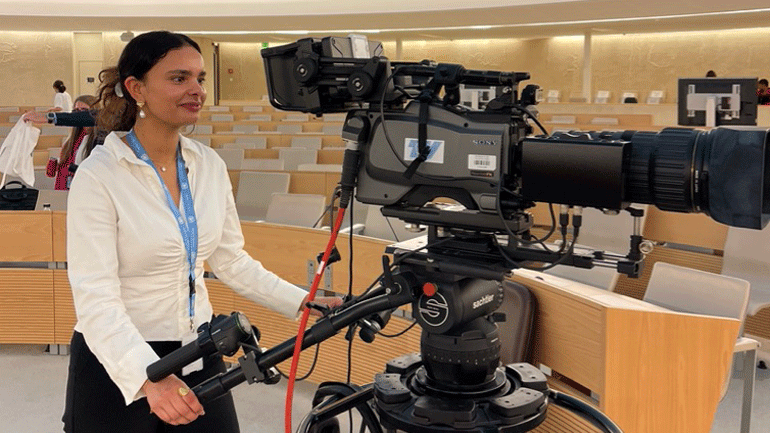 Cherine Randi Sellami styrar eit stort kamera i ein FN-sal. Foto