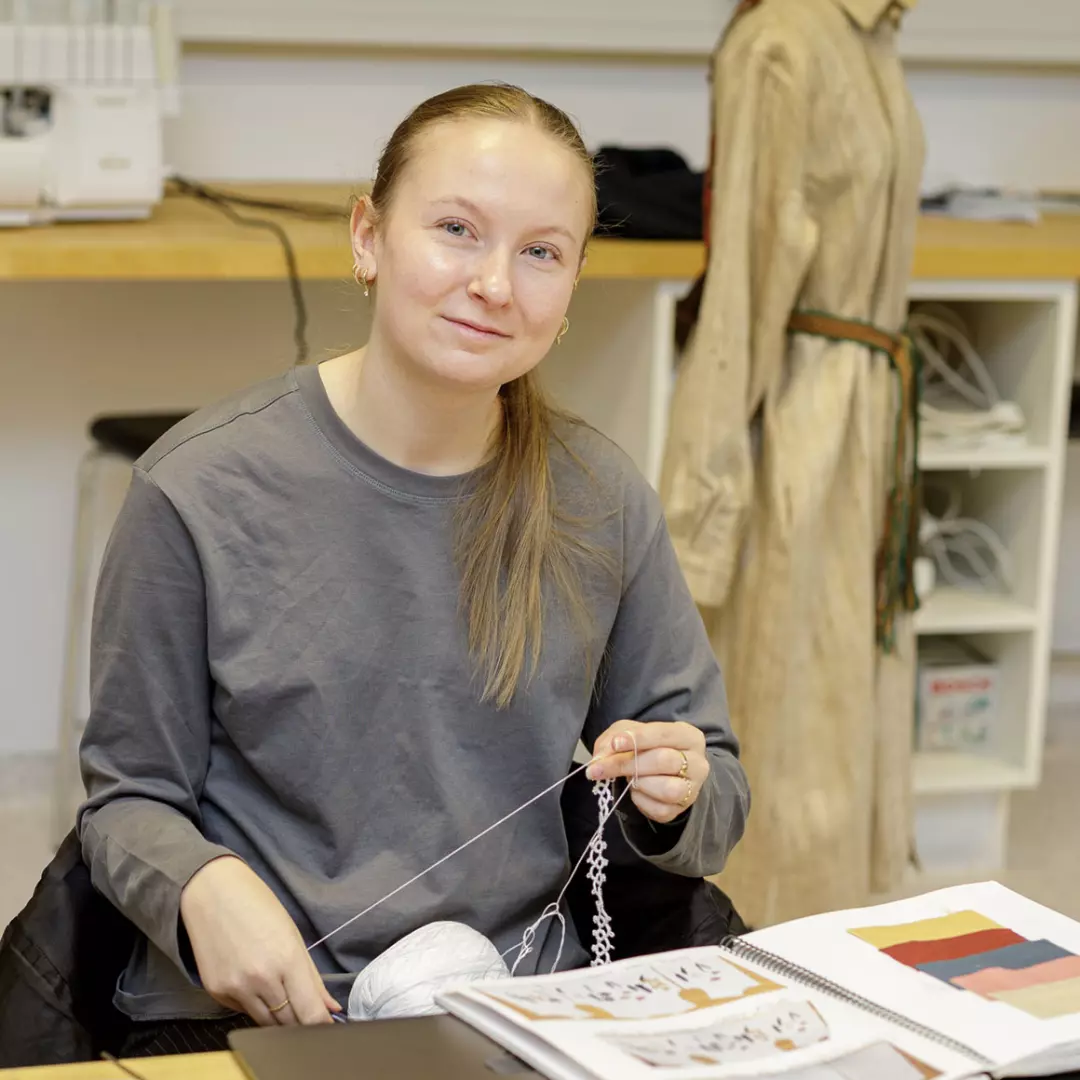 Student jobber med tekstil i klasserom