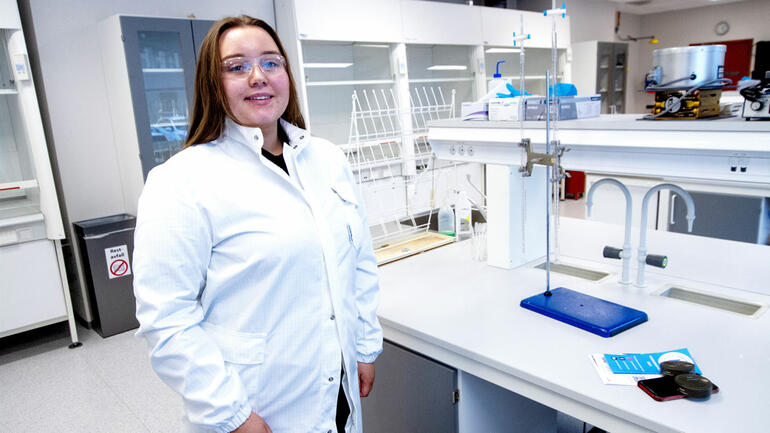 Kristine stående i laboratorium i hvit labfrakk