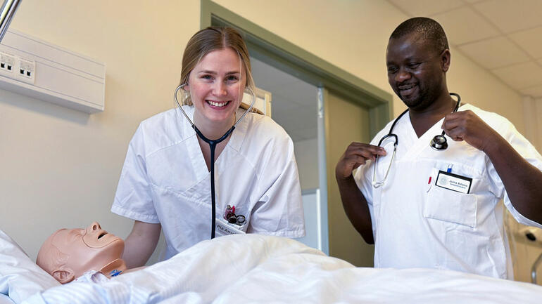 Sykepleierstudentene Pia Amalie Saga Berberg og Juma Adams,  ved sykeseng i simulatorrom på Campus Porsgrunn