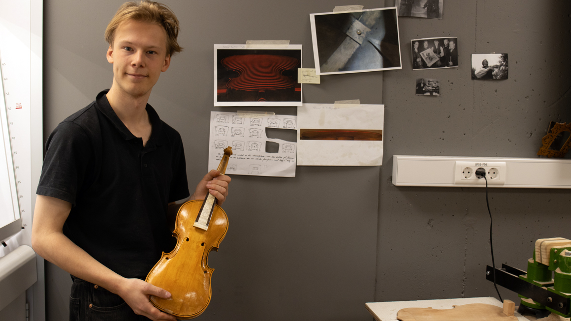 Student Kjetil Meberg Myren har tatt utgangspunkt i formen på en hardingfele signert Johannes B. Tveit fra 1822 når han skal lage eksamensarbeidet sitt fra et treemne i svartor. gutt med hardingfele