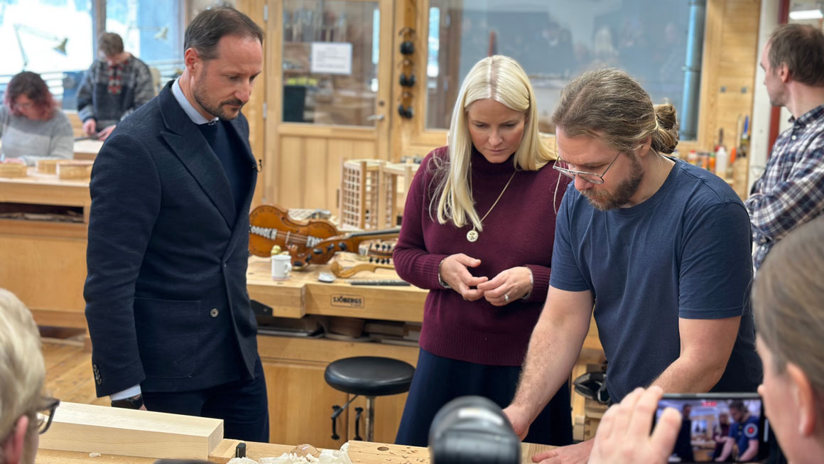 Her tar Benjamin Rygh imot kronprinsparet på verkstedet på campus Rauland da de besøkte Universitetet i Sørøst-Norge i 2023. (Foto: Ingvild Gjone Sildnes/USN) kronsprinsparet på instrumentmaking på campus rauland