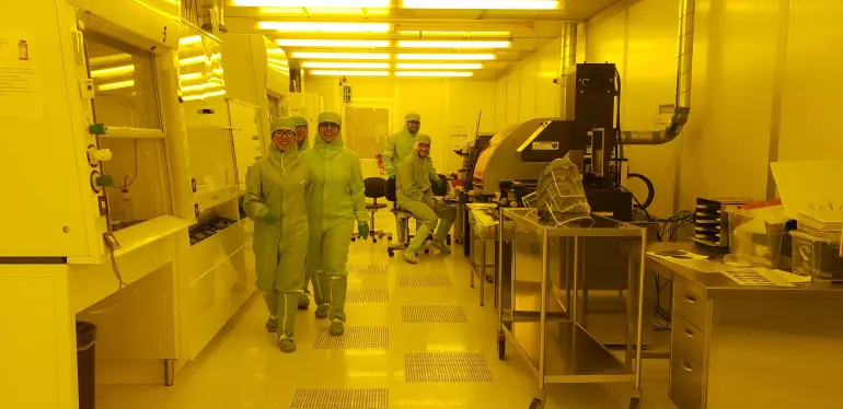 innsiden av et laboratorium med fem mennesker i fult ren-utstyr