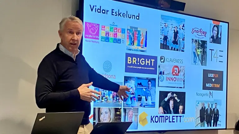 mann foran skjerm med en rekke bedriftslogoer