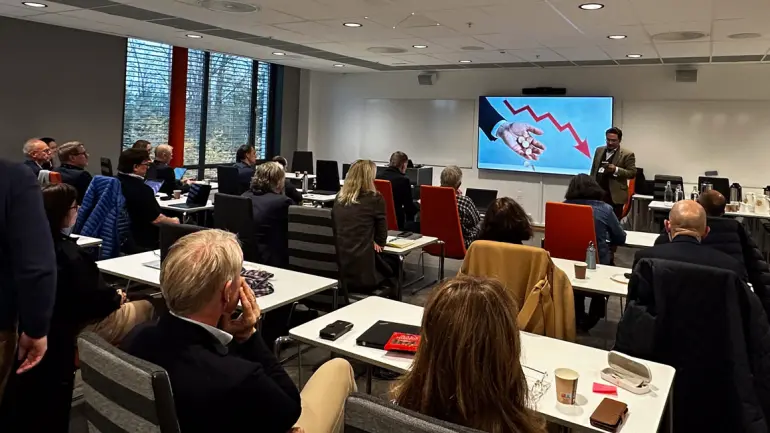 foredrag med rom fullt av folk som sitter og lytter