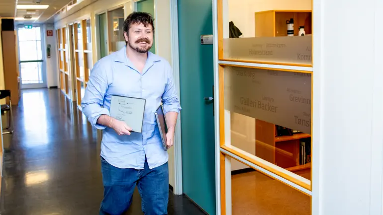 Bilde av Kyrre Kjellevold som går bortover en gang på campus