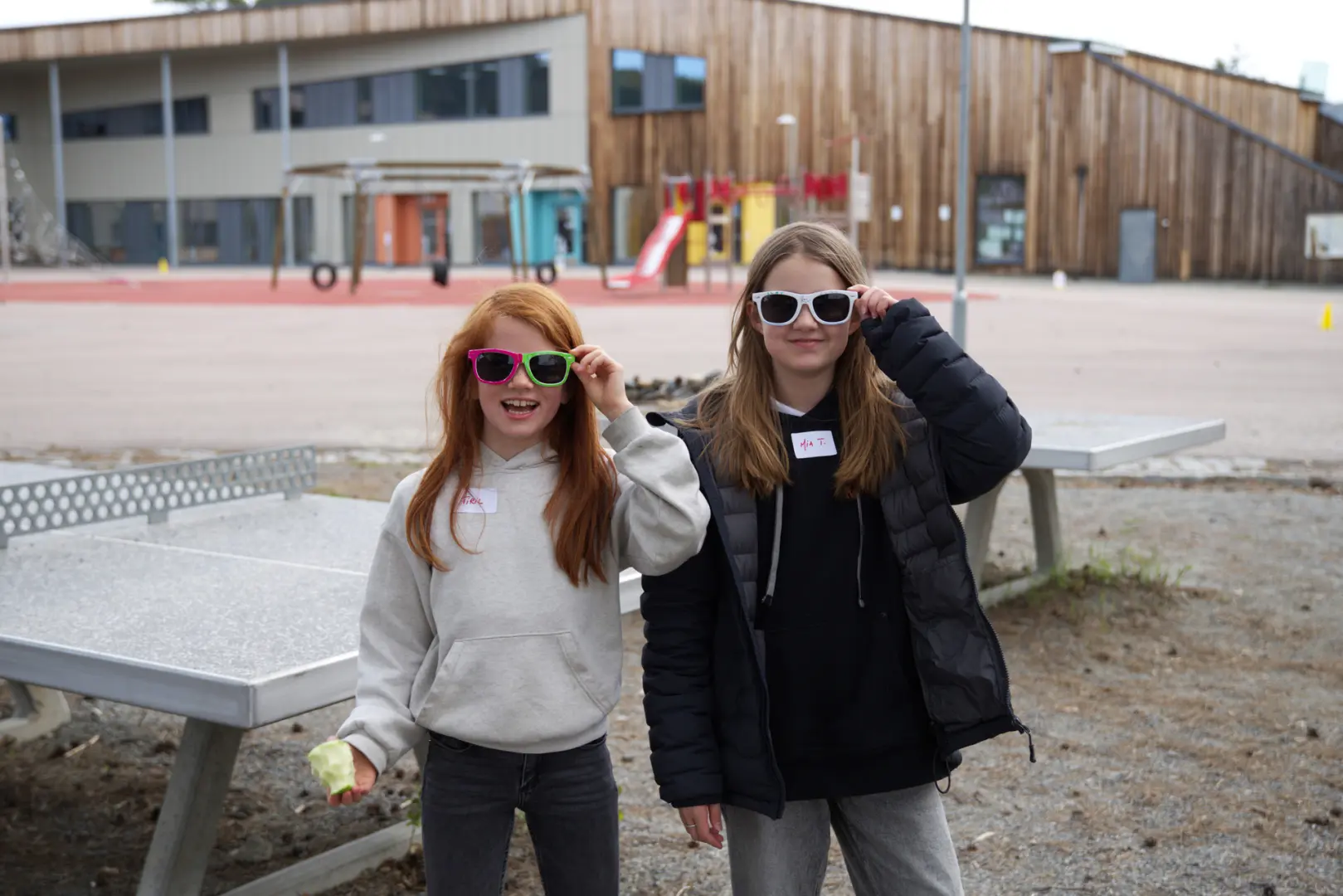 Elevene Tiril Langjord og Mia Tangerud tester solbrillene sine i skolegården.