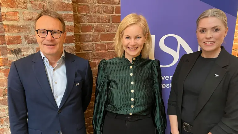 tre smilende mennesker foran logoen til USN