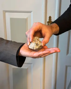 en hånd som overleverer en stein til en annen hånd