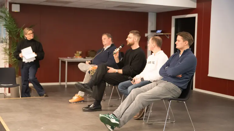 Fire stitter på en scene og diskuterer, snakker til publikum