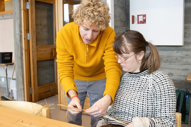 kursholder viser hvordan man fletter neslefiber