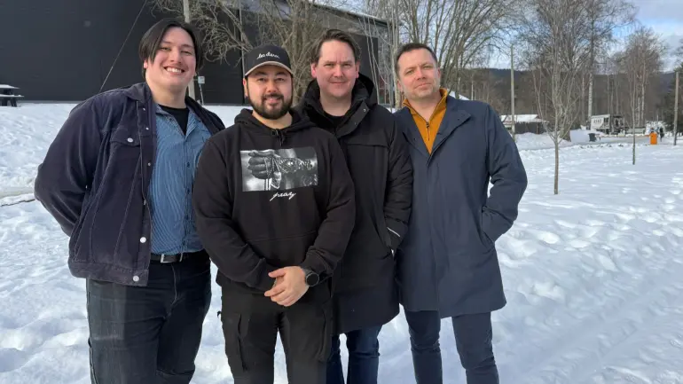 studenter smiler inn i kamera.