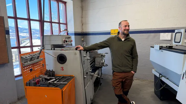 mann lener seg på maskin i industrihall på yrkesfaglig videregående skole