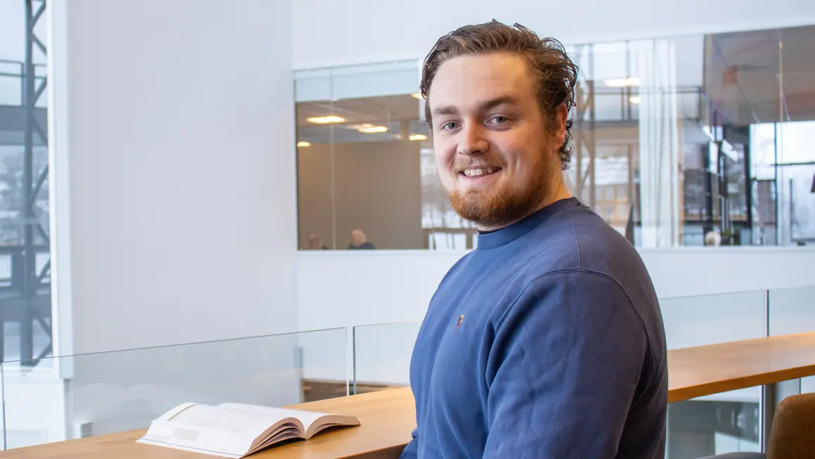 Portrett av Henrik ser i kamera og smiler