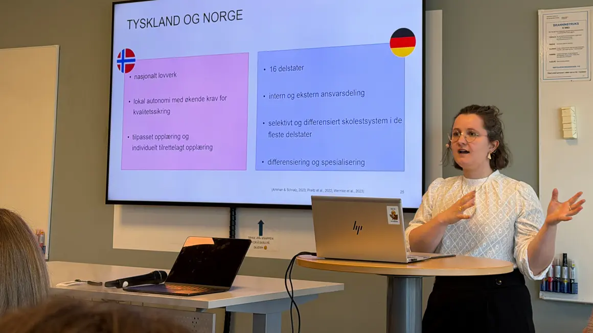 dame presenterer foran skjerm som viser forskjeller mellom norske og tyske skolesystemer