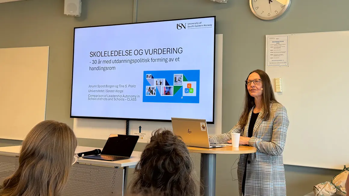 dame presenterer foran skjerm som viser temaet vurdering i skolen