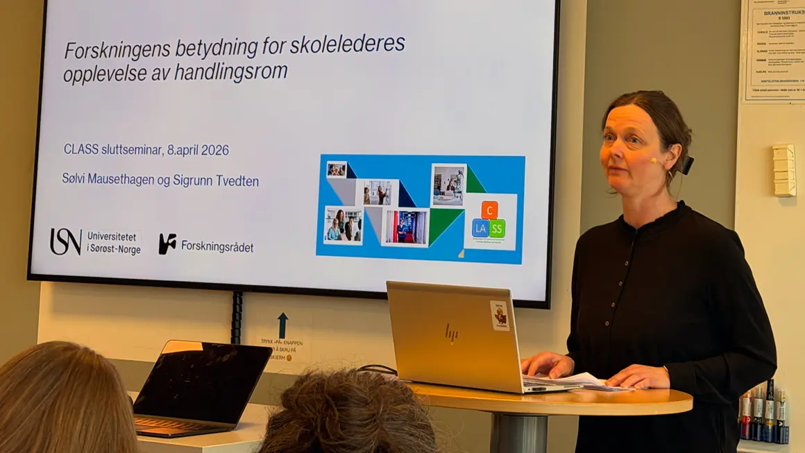 dame i svart presenterer skoleforskning