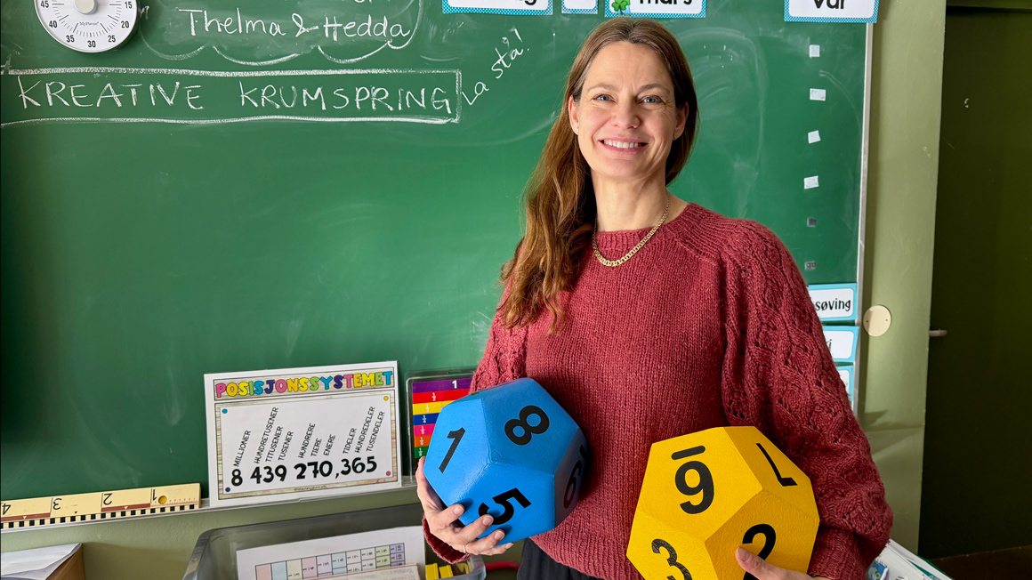 lærer med hjelpemidler til matte foran tavle i klasserom