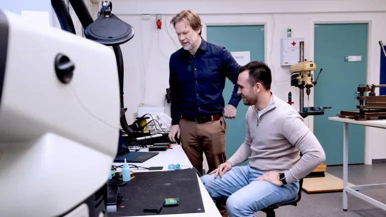 SIKKER JOBB: Som elektronikkingeniør er Alexander R. Belmonte ettertraktet på jobbmarkedet. Her er han i laboratoriet sammen med overingeniør Raymond Berg Hansen. (Foto: An-Magritt Larsen) ALexander i laboratoriet og jobber mesn overingenilr Raymond Berg Hansen spr p siden og ser på.