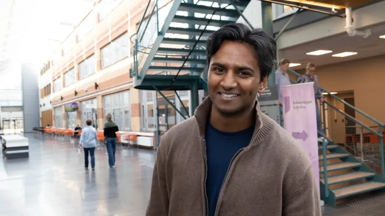 ENDRET VALGET: Krishan Anthonypillai var lenge usikker på hva han ville bli. Han skrotet plan A om å bli lærer og sikter nå mot en maritim karriere. (Foto: An-Magritt Larsen) Krishan stpende i gangen på USN campus Vestfold i halvfigur og smiler til kamera. iur