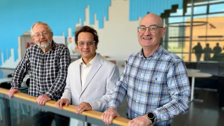 tre menn lener seg på nettverk i universitetsomgivelser