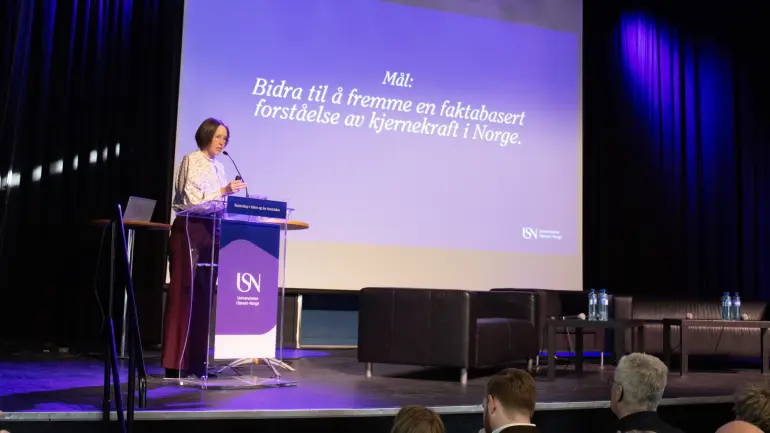 dame presenterer på scene med USN-logo