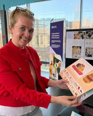 hanne finsrud viser fram bok med ASK-tegninger 