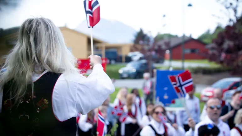 17.mai-tog med bunader og norske flagg