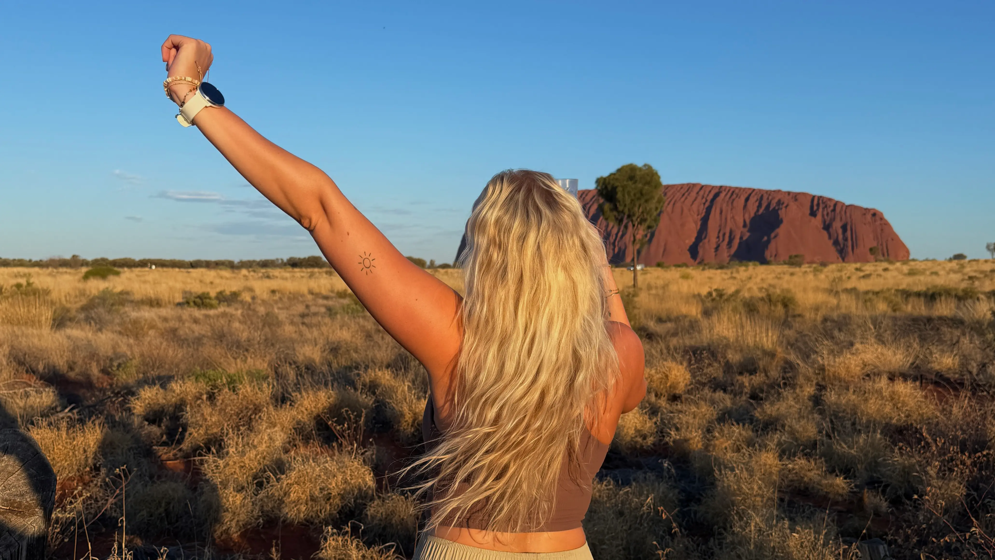Person med Ayers Rock i bakgrunnen