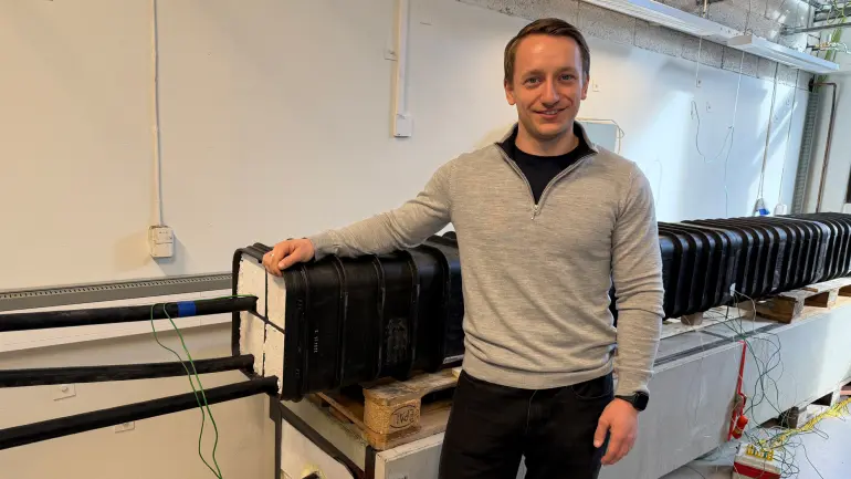 mann lener seg på kabler i en lab