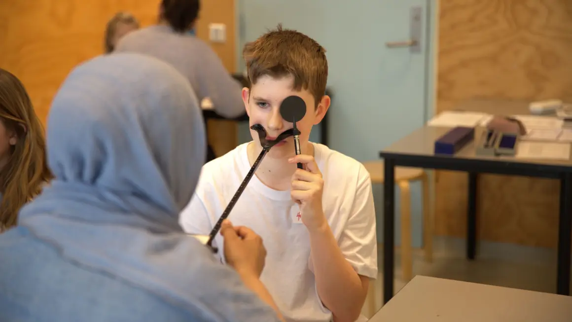 Optometristudent Mahnoor Ikram foretar en synsundersøkelse av elev Henrikas Pakarna. Fotograf: Ingvild Stokka Optometristudent Mahnoor Ikram foretar en synsundersøkelse av elev Henrikas Pakarna
