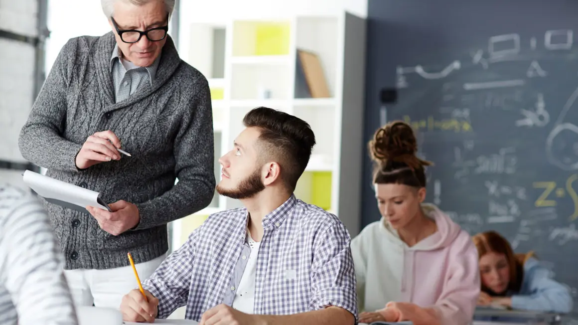 BLOMSTRER MED UTFORDINGER: Forelesere som setter pris på kritiske spørsmål var noe av det beste med å begynne å studere, ifølge de unge voksne som ikke var blitt møtt på samme måte på barneskolen. (Illustrasjonsfoto: Colourbox) lærer stopper opp og snakker med ungdom i klasserommet