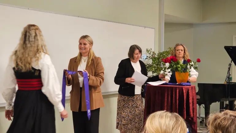Instituttleder Ösp Egilsdottir deler ut bånd og vitnemål til studentene. Førstelektor Lise Gladhus og instituttnestleder Kirsten Røland Byermoen (t.h.) bistår.. Fotograf: Maren Sofie Sandbakk Instituttleder Ösp Egilsdottir deler ut bånd og vitnemål til studentene. Førstelektor Lise Gladhus og instituttnestleder Kirsten Røland Byermoen (t.h.) bistår.